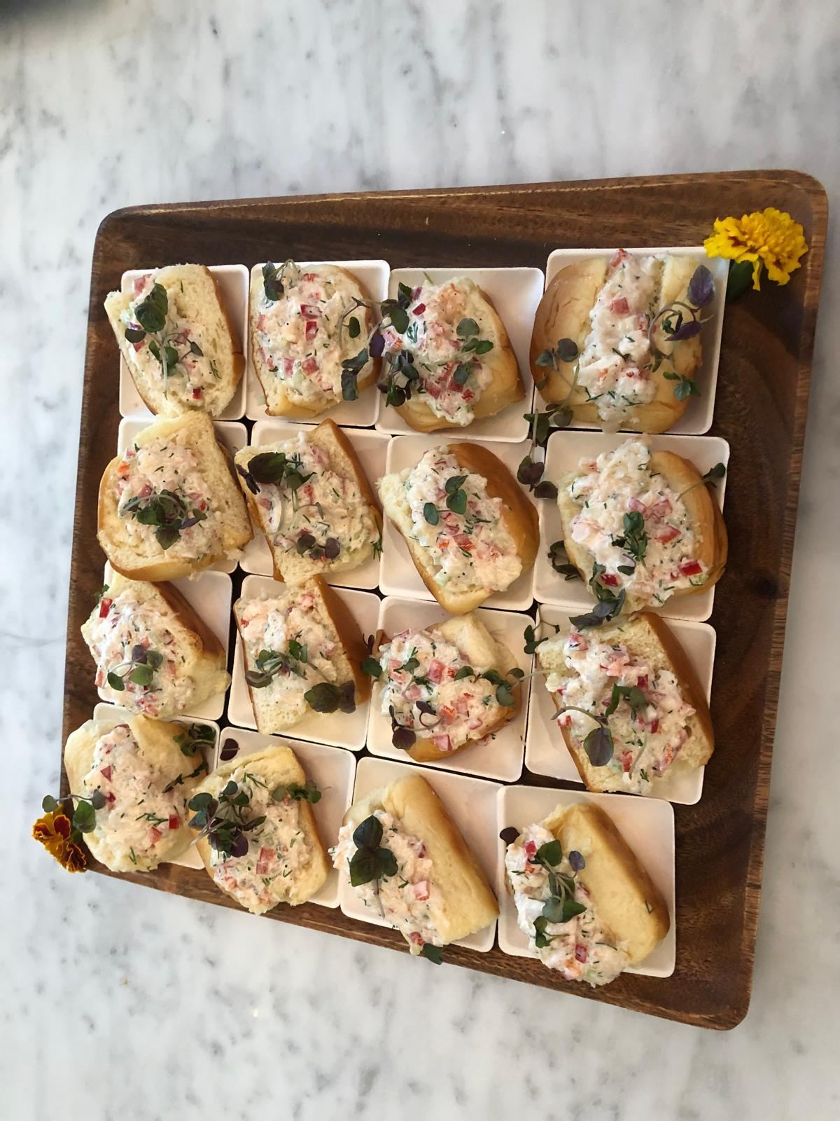 Mini lobster roll sliders on a wooden board